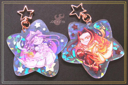 Photo by TB (tangentburd) of the double-sided acrylic charm design for Jolly Duck Club Merch Mart, featuring Asakura Hao from Shaman King in a holographic finish. One side has him in his battle outfit; the other side has him as Princess Hao.