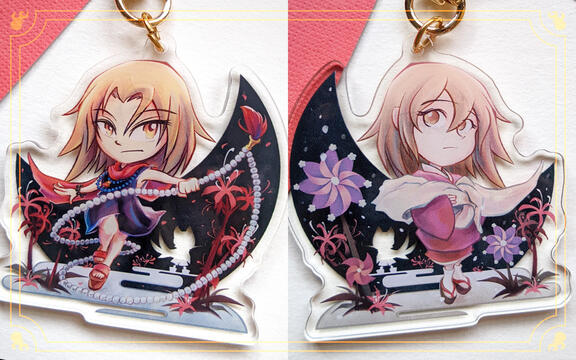 Photo by TB of an acrylic charm for the "Re:Voir" Shaman King Zine, featuring Kyouyama Anna. One side has her in a black dress with spider lilies; other side has her in a yukata with pinwheels. A white silhouette of Matamune is visible in both.
